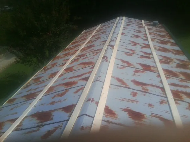Rusted metal roof panels with new wood purlins before replacement — Storm Damage Roof Repair in Battle Mountain by Roofing Brothers