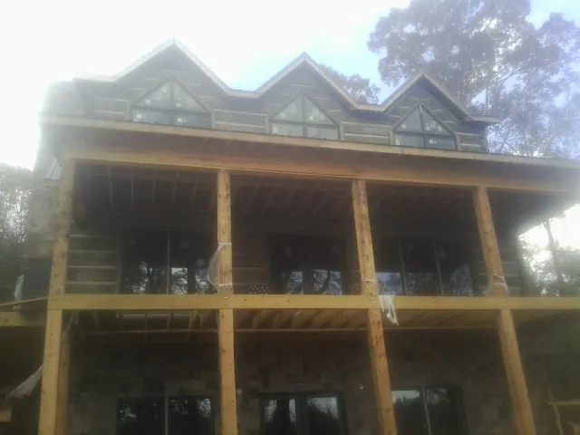 Dormers and porch framing on a large log home under construction — Roof Coating work by our crew in Battle Mountain