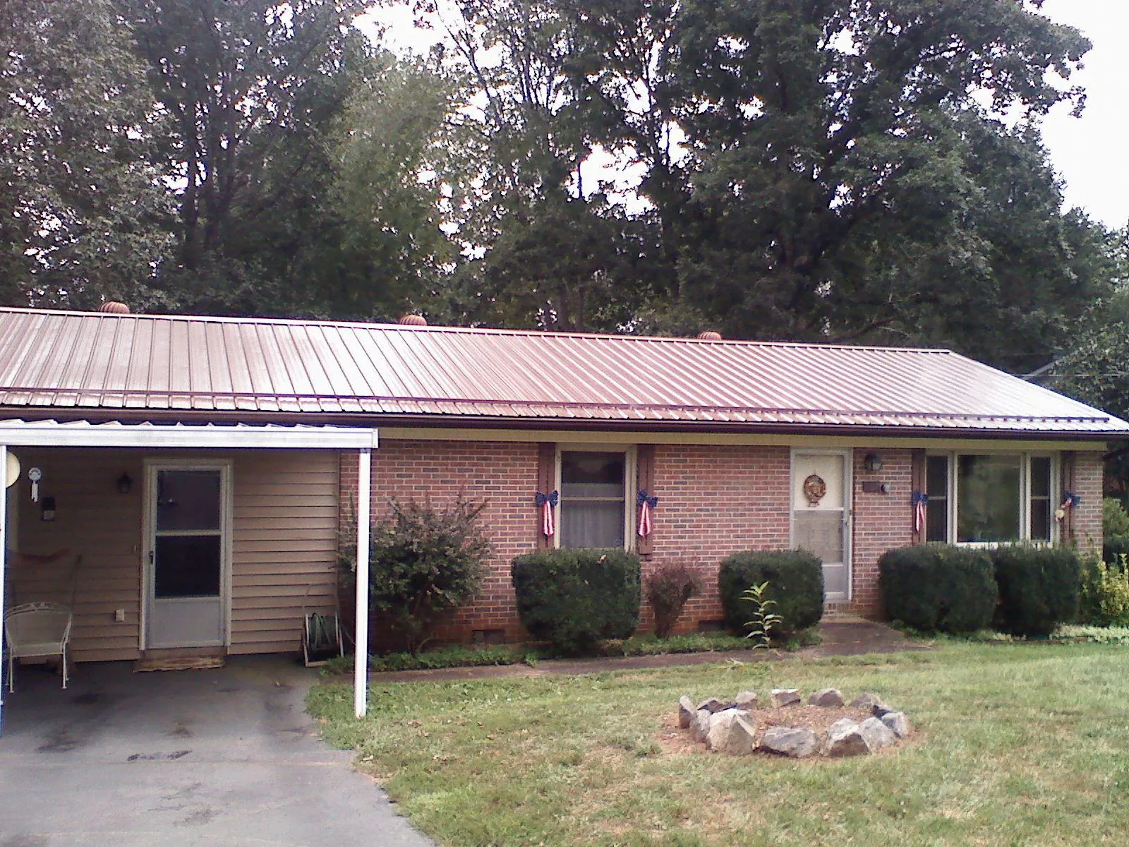Bronze metal roof and carport on a brick ranch home — Roof Repair work by our crew in Battle Mountain